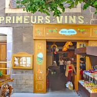 Traditionele Franse wijnwinkel 'Primeurs Vins' met houten winkelpui, buitenvertoning van lokale producten in stenen gebouw in de Provence.