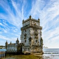 Belém-toren aan de Taag in Lissabon Historische Belém-toren in de Taag in Lissabon, Portugal, met sierlijke Manuelijnse architectuur onder dramatische bewolkte hemel.