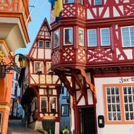 Kleurrijke middeleeuwse vakwerkgebouwen in Bernkastel-Kues met rood-witte balken, uitbouwen en kasseien.