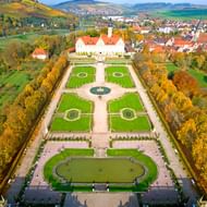 Luchtfoto van Schloss Weikersheim met symmetrische baroktuinen met geometrische gazons, paden en herfstbomen in Duitsland.