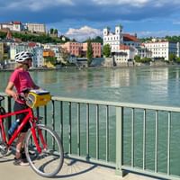Cyclist during a stopover on a bridge with a view of Passau