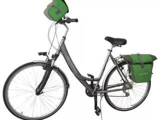 Grijze toerfiets met lage instap, uitgerust met groene fietstassen op achterdrager en groene stuurtas.