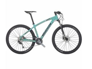 Turquoise Bianchi UAMB mountainbike met zwarte banden, schijfremmen en verende voorvork op witte achtergrond.