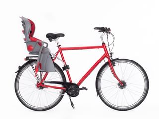 Rode stadsfiets met grijs-rood kinderzitje op bagagedrager, zwart zadel en zilveren stuur op witte achtergrond.