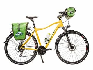 Gele toerfiets met groene FunActive fietstassen op bagagedrager en stuur, bidon, schijfremmen en standaard op witte achtergrond.