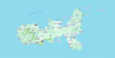 Kaart van Elba met wandelroute in groen, steden als Portoferraio, Marina di Campo en Porto Azzurro, met roze locatiemarkering.