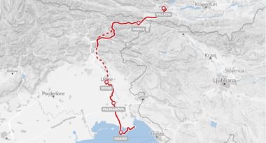 Kaart van de Alpe Adria fietsroute van Villach naar Grado via Tarvis, Udine en Palmanova met rode lijn door bergachtig terrein.