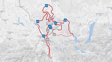 Kaart met rode fietsroutes vanuit Seeham bij Salzburg, Oostenrijk. Blauwe fietspictogrammen markeren verschillende bestemmingen van de sterrit.