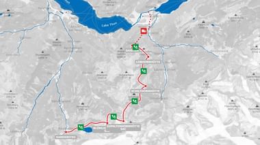 Wandelkaart met rode route van Thunersee door berghutten in Berner Oberland, met groene hutmarkeringen en hoogteaanduidingen.