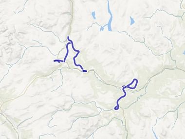 Topografische kaart van de Dovre-regio met gemarkeerde blauwe routes, rivieren en bergachtig terrein in beige en grijze tinten.