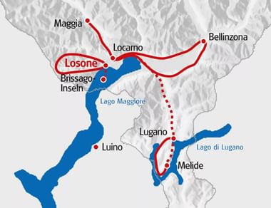 Kaart met fietsroute rond Lago Maggiore met rode lijnen die steden zoals Locarno, Bellinzona, Lugano en Melide bij Lago di Lugano verbinden.