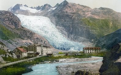 Historisch zicht op de Rhonegletsjer die van besneeuwde toppen bij Furkapass naar beneden stroomt, met traditionele Zwitserse gebouwen in het dal.