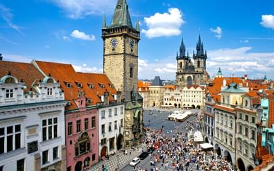 Luchtfoto van het Oude Stadsplein van Praag met de Astronomische Kloktoren en Týn-kerktorens. Kleurrijke barokgebouwen omringen het plein.