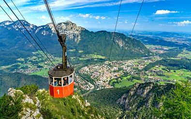 Rode Predigtstuhlbahn kabelbaan nummer 1 boven Bad Reichenhall dal met Alpenbergen en groen landschap eronder.