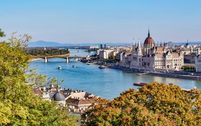 Panoramisch uitzicht op de wijk Pest in Boedapest met het Hongaarse Parlementsgebouw en zijn kenmerkende koepel langs de Donau met brug.