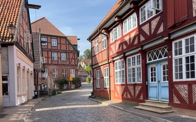 Geplaveide straat in historische oude stad Lauenburg met traditionele vakwerkhuizen met rode en witte gevels en dakpannen.