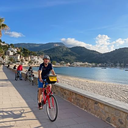 Cyclists on the paved cycle path along the beach of Port de Soller