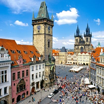 Luchtfoto van het Oude Stadsplein van Praag met de Astronomische Kloktoren en Týn-kerktorens. Kleurrijke barokgebouwen omringen het plein.