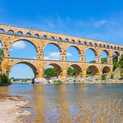 De antieke Romeinse Pont du Gard aquaductbrug met drie rijen bogen over de rivier de Gardon in de Provence, Frankrijk.