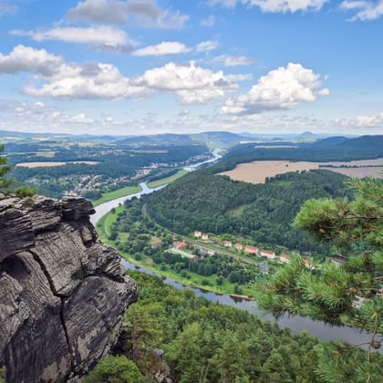 Panoramisch uitzicht vanaf Lilienstein op de Elbe die door beboste heuvels kronkelt, met dorpen en akkers in het dal.