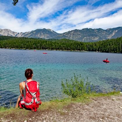 Hiker sits on the shore of Lake Eibsee