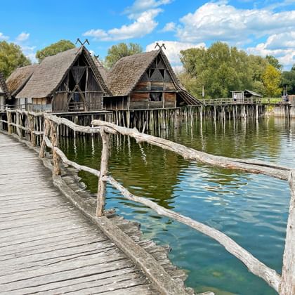 Houten loopbrug naar gereconstrueerde prehistorische paalwoningen boven het Bodenmeer in het museum Unteruhldingen.