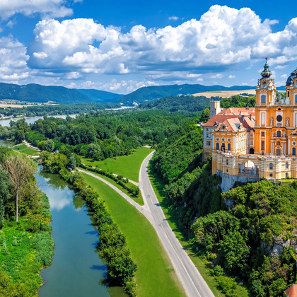 Luchtfoto van de abdij van Melk, een barok klooster met oranje gevel en twee torens, op een rots boven de Donau in de Wachau, Oostenrijk.